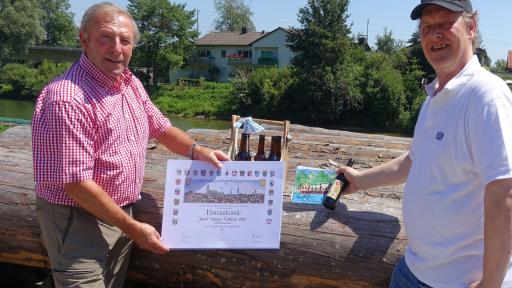 Unser Kassier Hermann Paetzmann (rechts) gratuliert Josef Seitner herzlich zum stolzen Firmenjubiläum. Geschenke gab’s auch: neben einer Karte sechs Flaschen Flößerbier in einer „Männerhandtasche“ (vom Wolfratshauser Wunschtraum). 